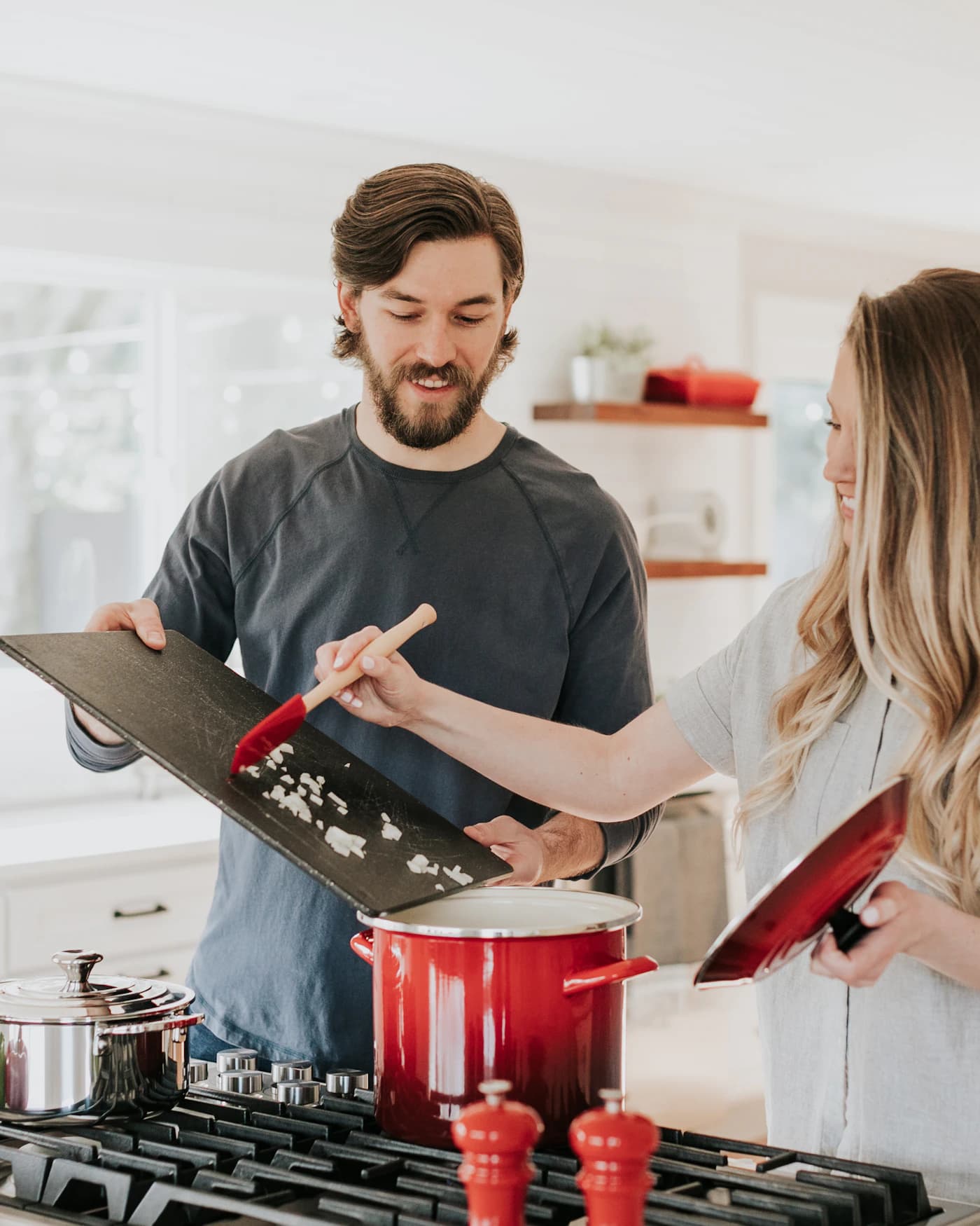 Two people cooking together in a bright kitchen.