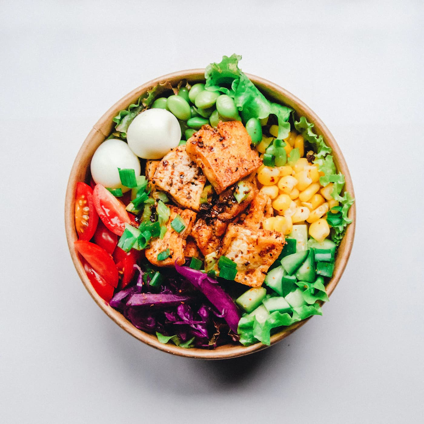 Chicken Cobb power bowl with egg, corn, tomato and cabbage.