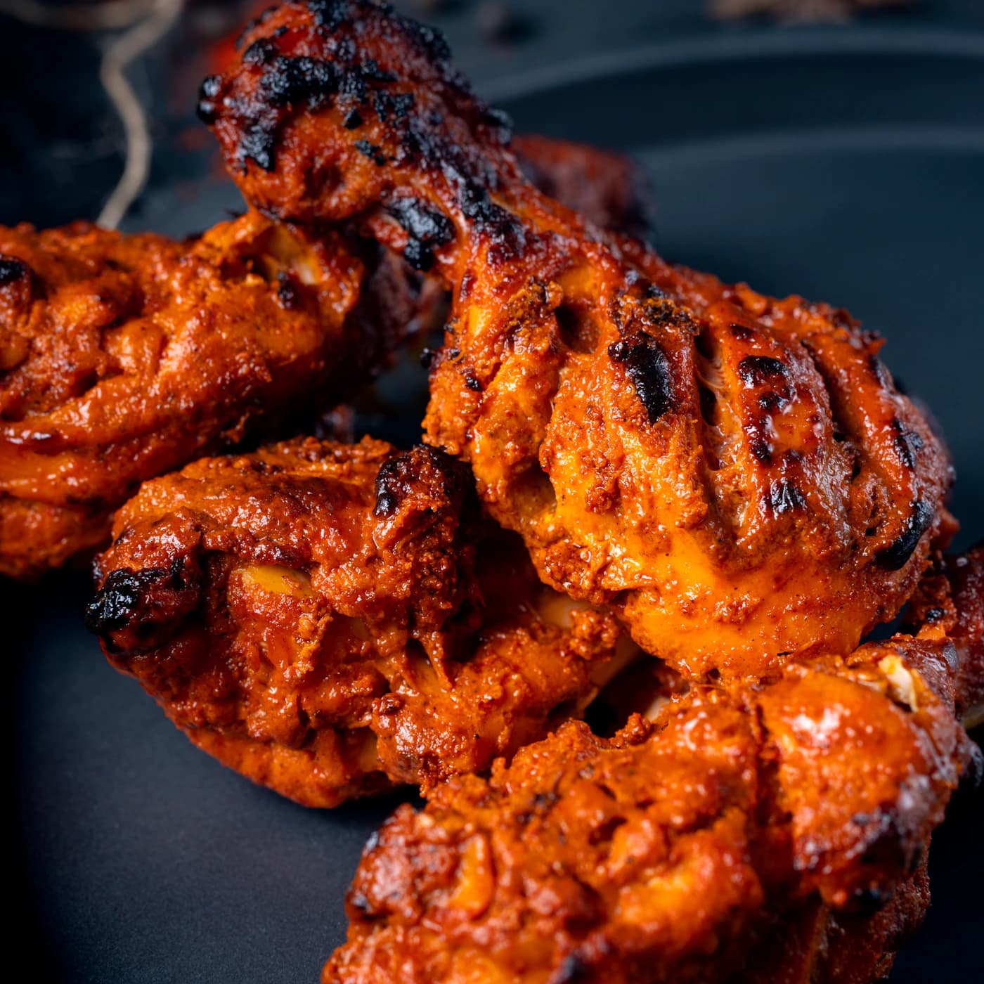 Charred tandoori-spiced chicken pieces.